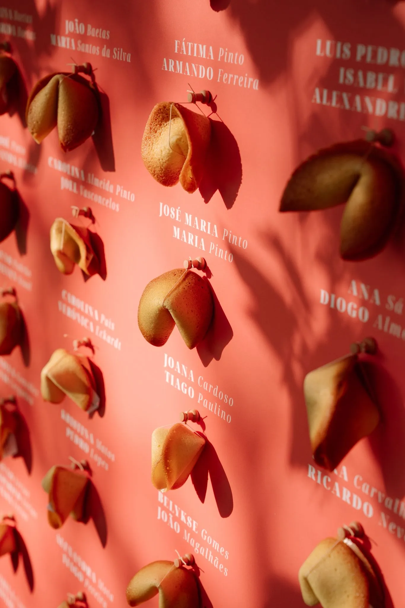 A coral seating wall hung with named fortune cookies